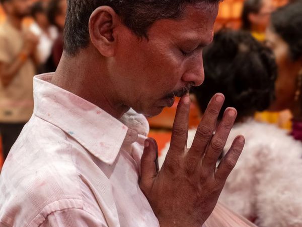 Close-up of a person's hands in a peaceful gesture during meditation.